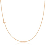 A rose gold necklace with a pave letter L charm on a white background. 