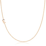 A rose gold necklace with a E letter charm on a white background. 