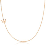 A rose gold necklace with a W letter charm on a white background. 