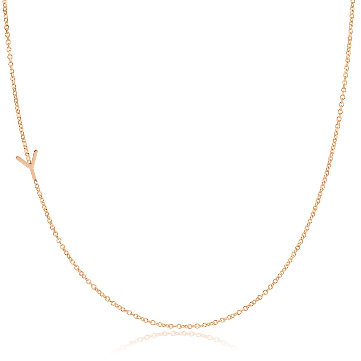 A rose gold necklace with a Y letter charm on a white background. 