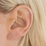 Close-up of a 14K Gold Number Stud in rose gold and 8 in a blonde woman's ear.