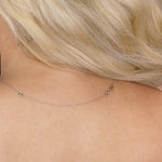 A white gold Chain Extender shown on the back of a neck with blonde hair. 