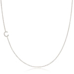 A white gold necklace with a pave letter C charm on a white background. 