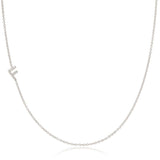 A white gold necklace with a F letter pave charm on a white background. 