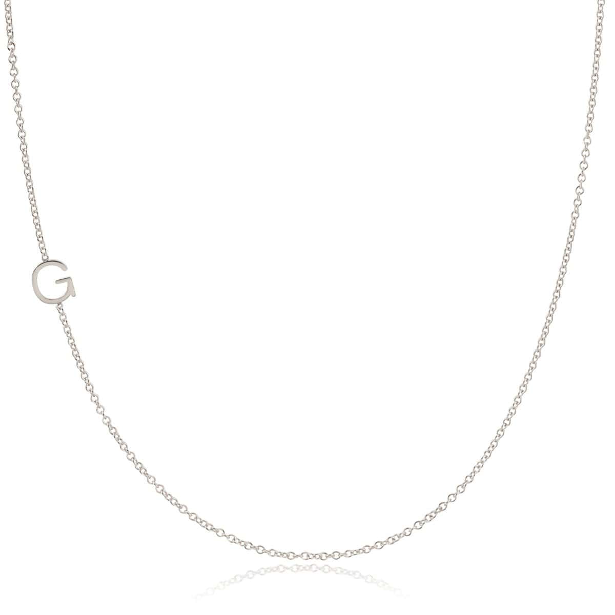 A white gold necklace with a G letter charm on a white background. 