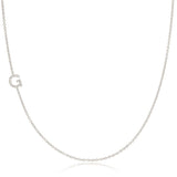 A white gold necklace with a G letter pave charm on a white background. 