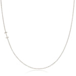A white gold necklace with an I letter charm on a white background. 