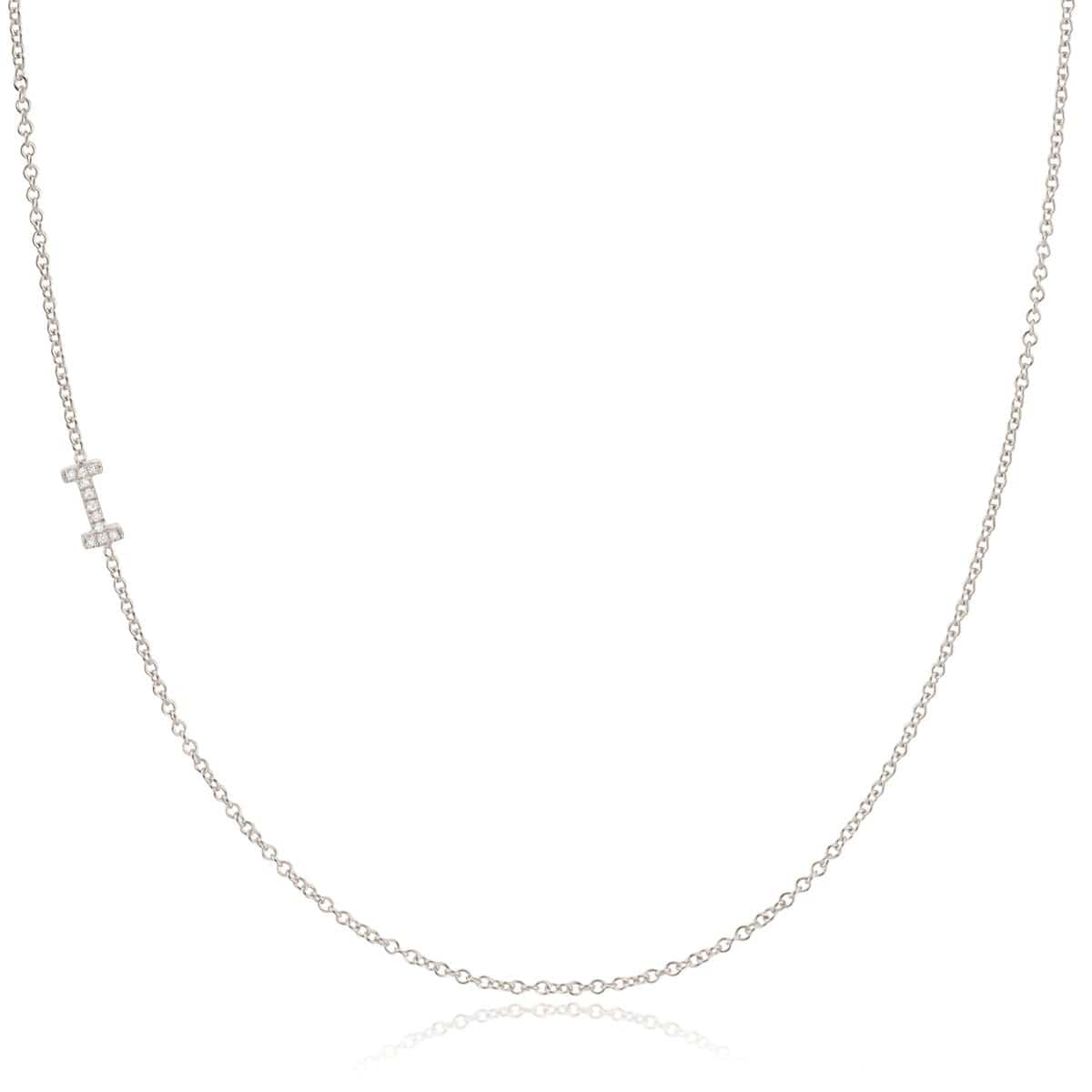 A white gold necklace with a letter I pave charm on a white background.