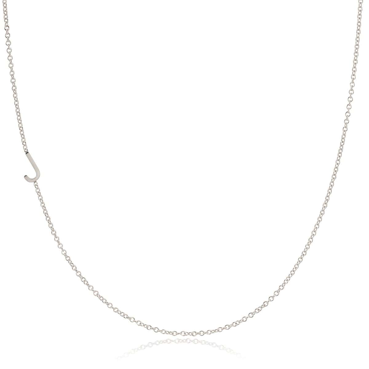 A white gold necklace with a J letter charm on a white background. 
