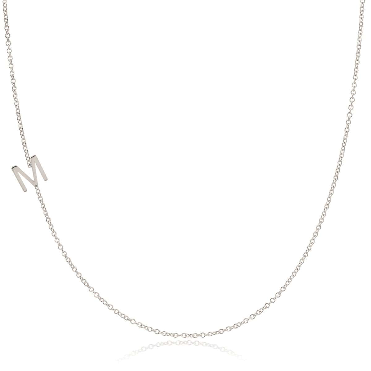 A white gold necklace with an M letter charm on a white background. 