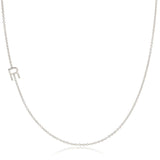 A white gold necklace with an R letter charm on a white background. 