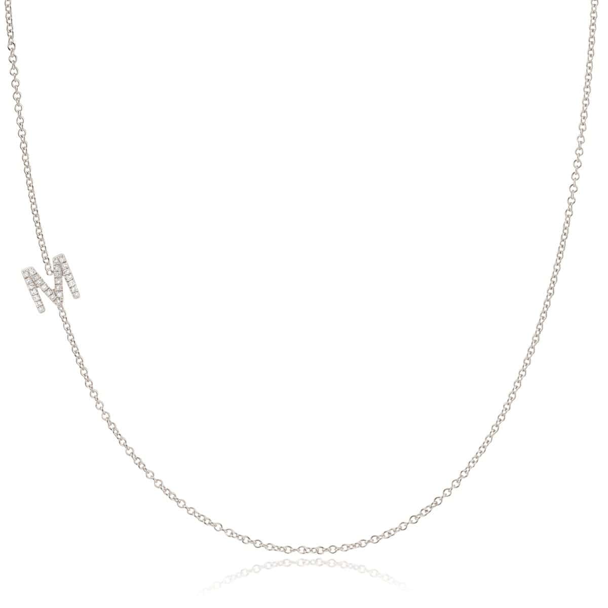 A white gold necklace with a letter M pave charm on a white background.