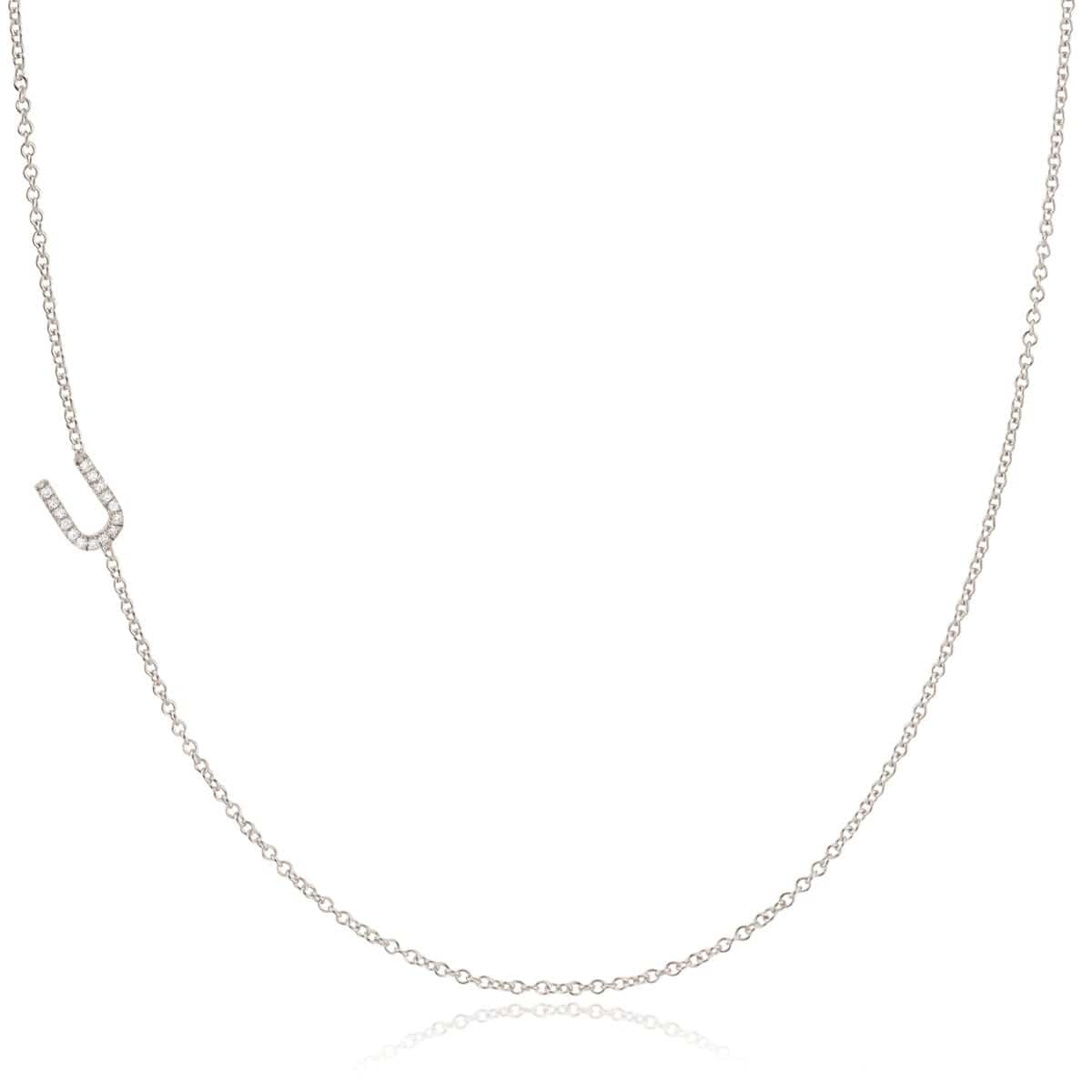 A white gold necklace with a letter U pave charm on a white background.