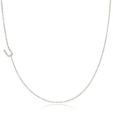 A white gold necklace with a letter U pave charm on a white background.