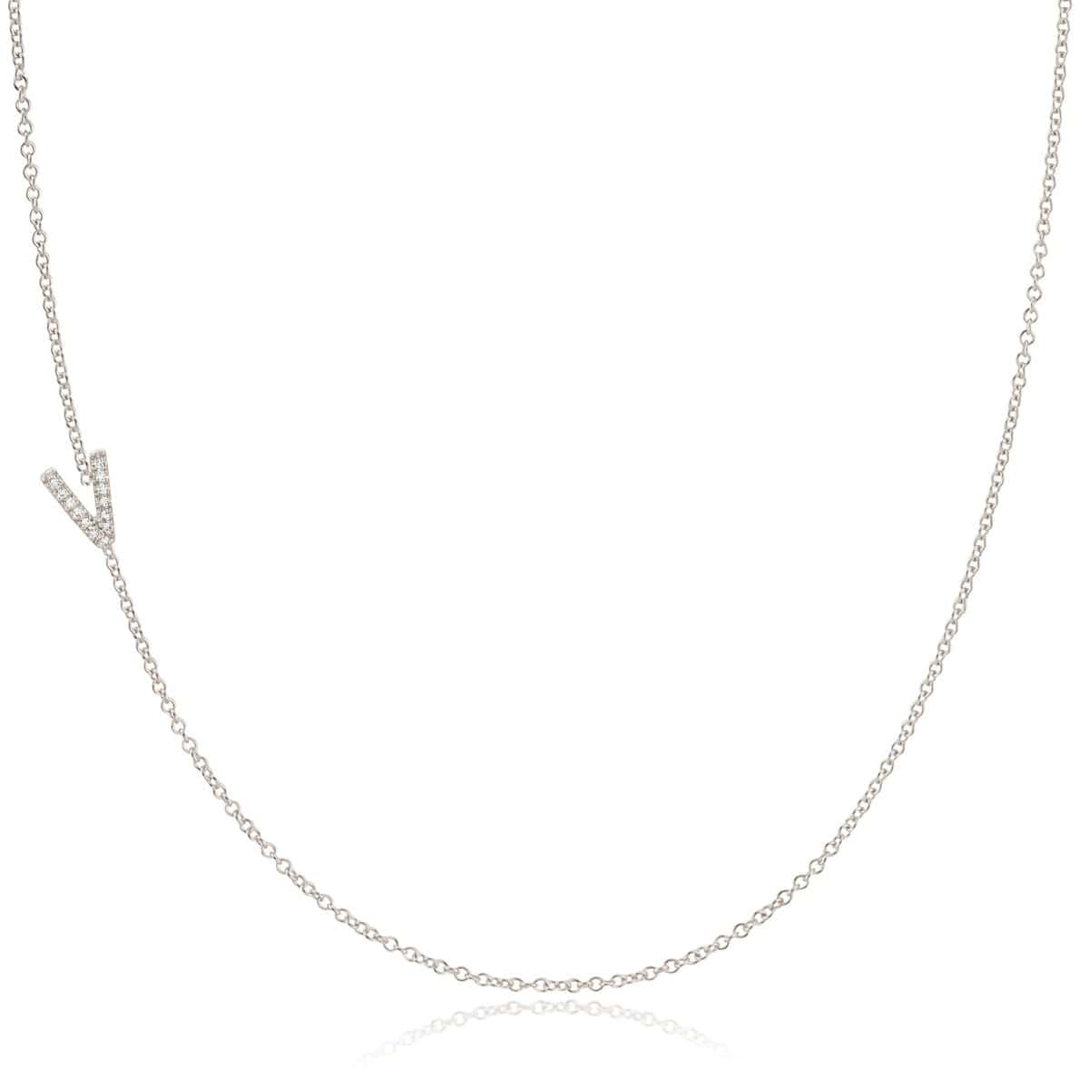 A white gold necklace with a letter V pave charm on a white background.