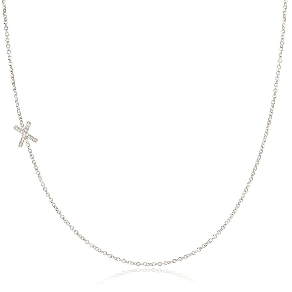 A white gold necklace with a letter X pave charm on a white background.