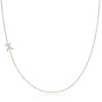 A white gold necklace with a letter X pave charm on a white background.