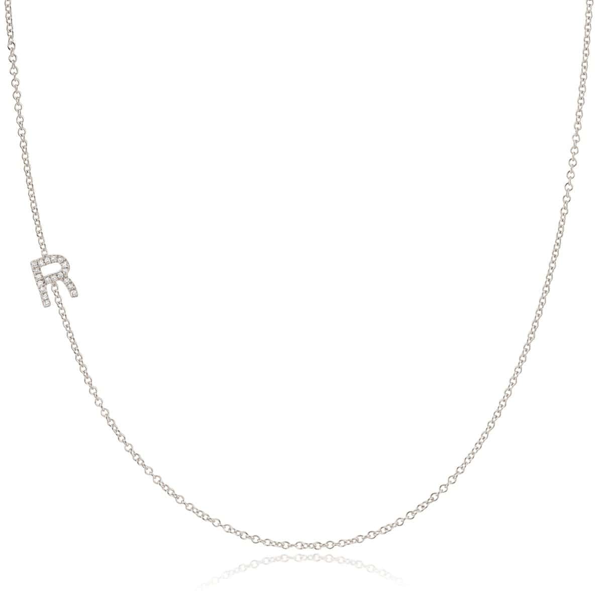 A white gold necklace with a letter R pave charm on a white background.