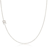 A white gold necklace with a letter R pave charm on a white background.