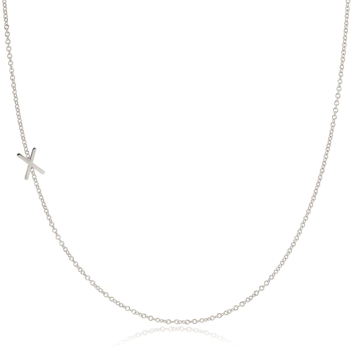 A white gold necklace with a X letter charm on a white background. 