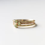 Three yellow gold Birthstone Rings in Peridot - August on a white background.