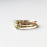 Three yellow gold Birthstone Rings in Peridot - August on a white background.
