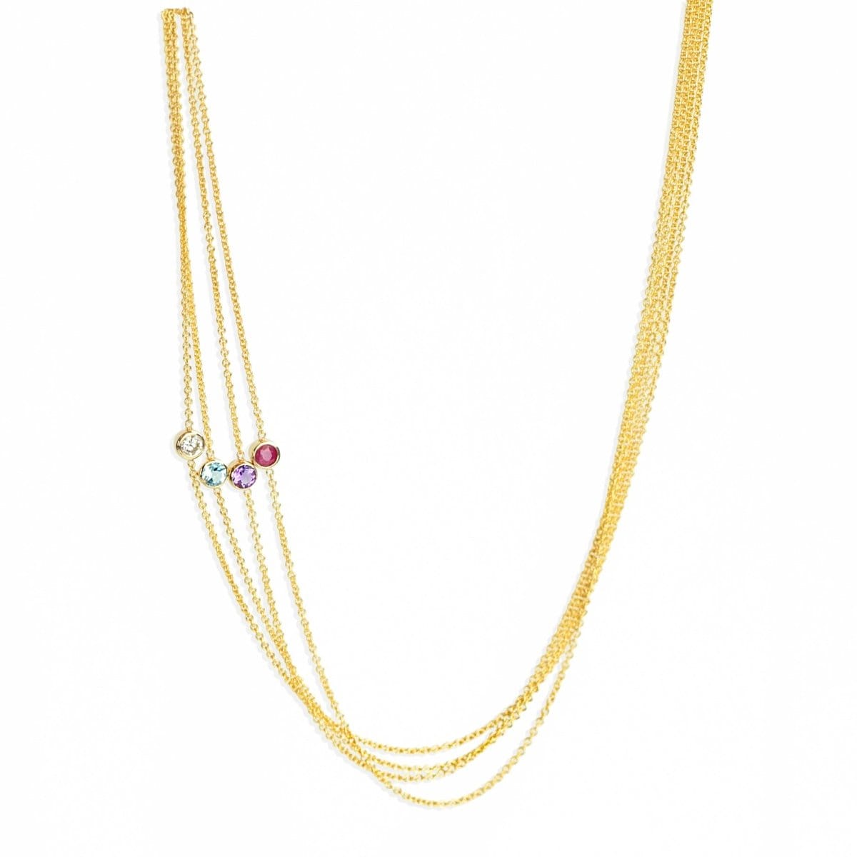 Four yellow gold 14K Gold Asymmetrical Birthstone Necklaces - Diamond (April), Aquamarine (March) and Tanzanite (December) and Garnet (January) on a white background. 