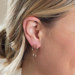 A Cascading Open Eclipse Earring in yellow gold shown on a blonde woman's ear. 