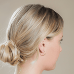 Side profile of a woman wearing a Crescent Hoop / Medium with her blonde hair in a bun against a neutral background. 