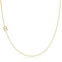 A yellow gold necklace with a pave letter R charm on a white background.