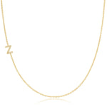 A yellow gold necklace with a pave letter Z charm on a white background. 
