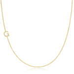A yellow gold necklace with a pave letter G charm on a white background. 