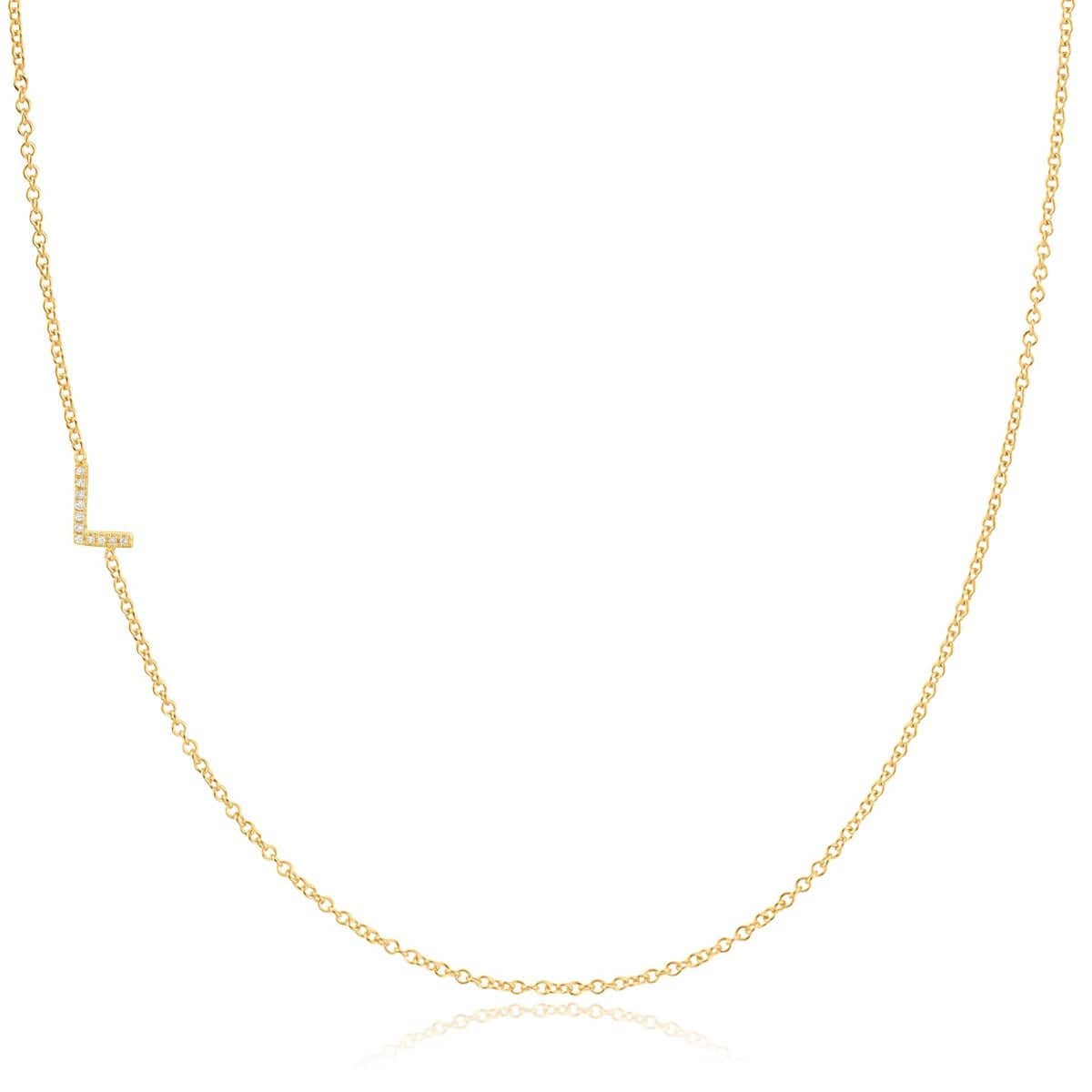 A yellow gold necklace with a pave letter L charm on a white background. 