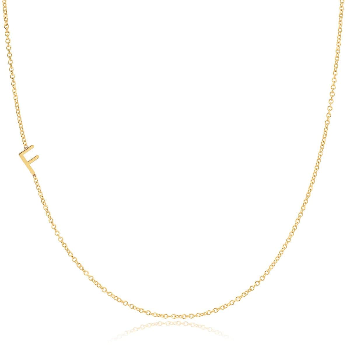 A yellow gold necklace with a F letter charm on a white background. 