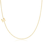 A yellow gold necklace with an M letter charm on a white background. 