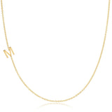 A yellow gold necklace with an M letter charm on a white background. 