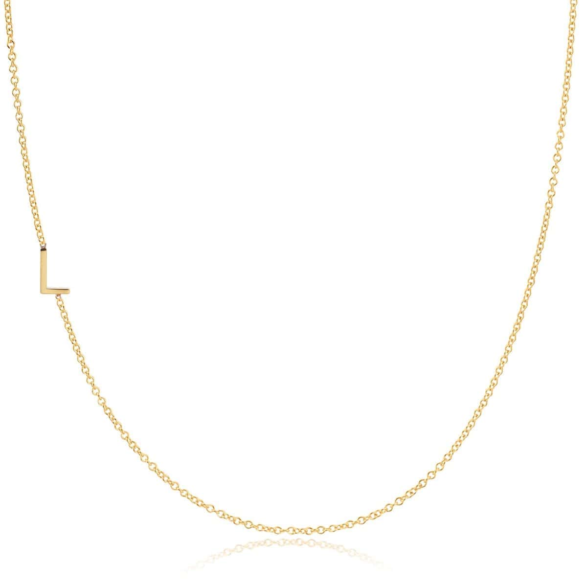 A yellow gold necklace with an L letter charm on a white background. 