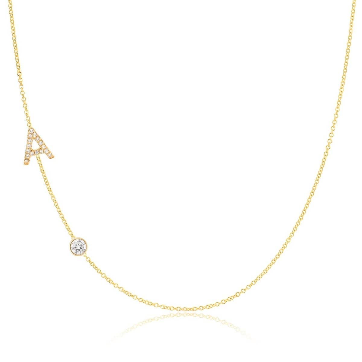 A Pavé Monogram Necklace with Diamond  and a letter A charm in yellow gold on a white background.