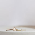 A rose gold Twinkle Twinkle Ring and yellow gold Birthstone Ring (Diamond) against a light grey blurred background.