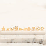 Assorted yellow gold charm studs on marble with a white background