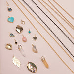 A Box Chain, Black Rhodium Antique Bead Chain, Oval Link Chain, Round Curb Chain,  Opal Dangle Charm, Small Abalone Cabochon Charm, Turquoise Heart Charm,
Cut Out Heart Charm, Diamond Heart Locket Charm, Abalone Leaf Charm, Turquoise Dangle Charm, Pink Opal Tear Drop Charm, Onyx Dangle Charm, Engraved Heart Charm, Heart Locket Charm, two Balance Crystal Charms, Moonstone Crescent Charm, 20th Anniversary Leaf Pendant and a Large Abalone Cabochon Charm against a light pink background. 