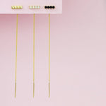 An Alli Webb Faceted Threader, Onyx Threader and Opal Threader against a light pink background. 