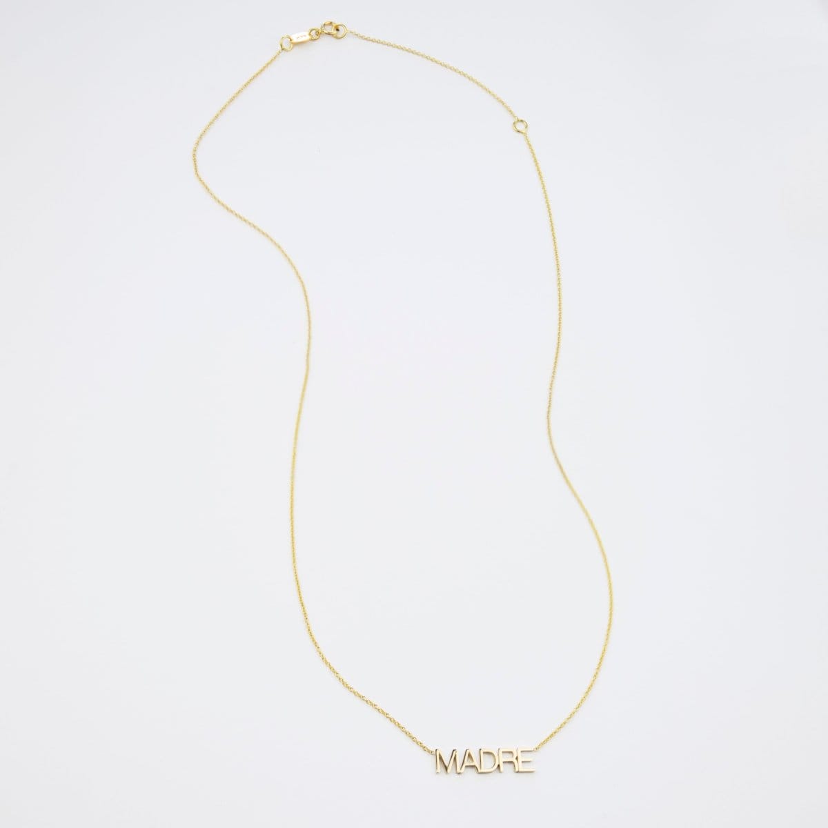 A Madre Necklace in yellow gold on a white background. 