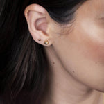 Close-up of a yellow gold Mini Preppy Post and Preppy Post in a brunette woman's ear. 