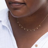Close-up of a person's neck wearing a Stardust Diamond Necklace with a white shirt. 