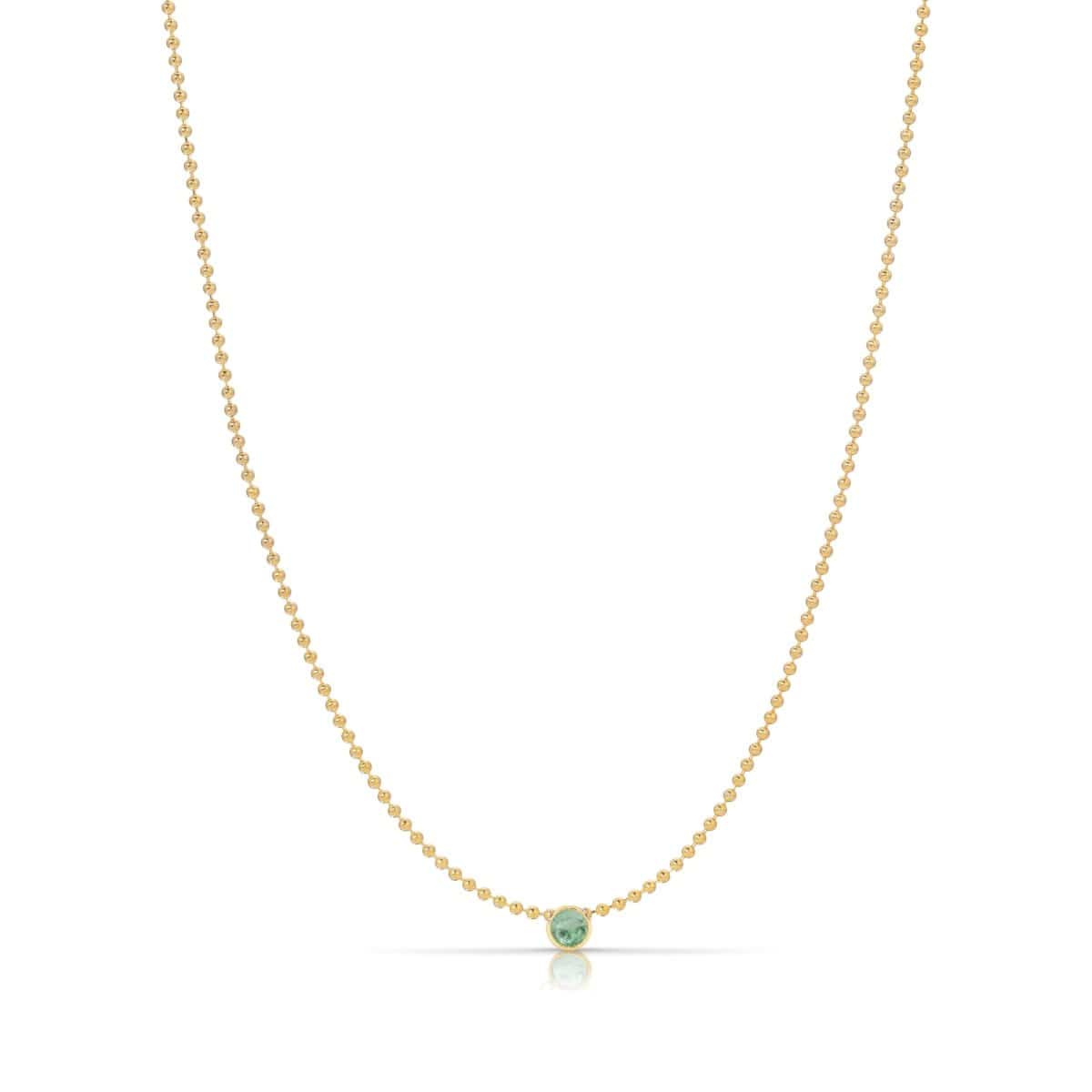 A Single Birthstone Layering Necklace - Yellow Gold in Emerald - May on a white background.