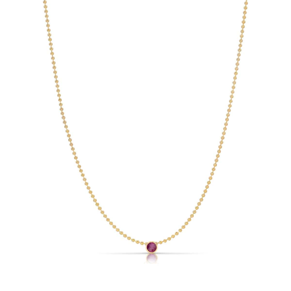 A Single Birthstone Layering Necklace - Yellow Gold in Ruby - July on a white background.