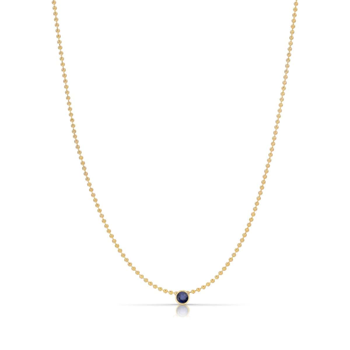 A Single Birthstone Layering Necklace - Yellow Gold in Sapphire - September on a white background.