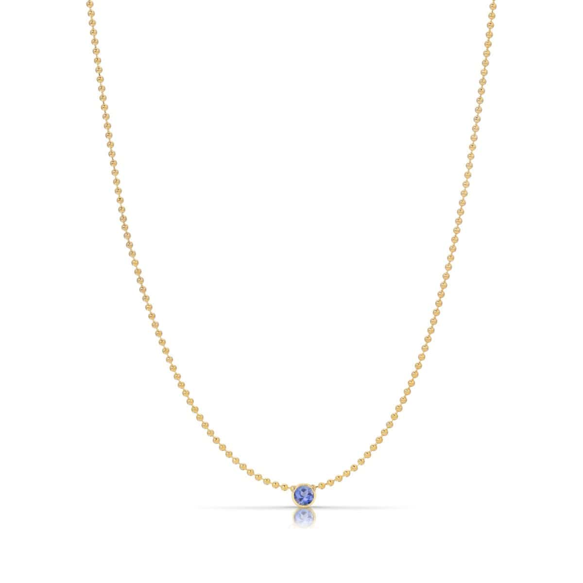 A Single Birthstone Layering Necklace - Yellow Gold in Tanzanite - December on a white background.