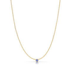 A Single Birthstone Layering Necklace - Yellow Gold in Tanzanite - December on a white background.